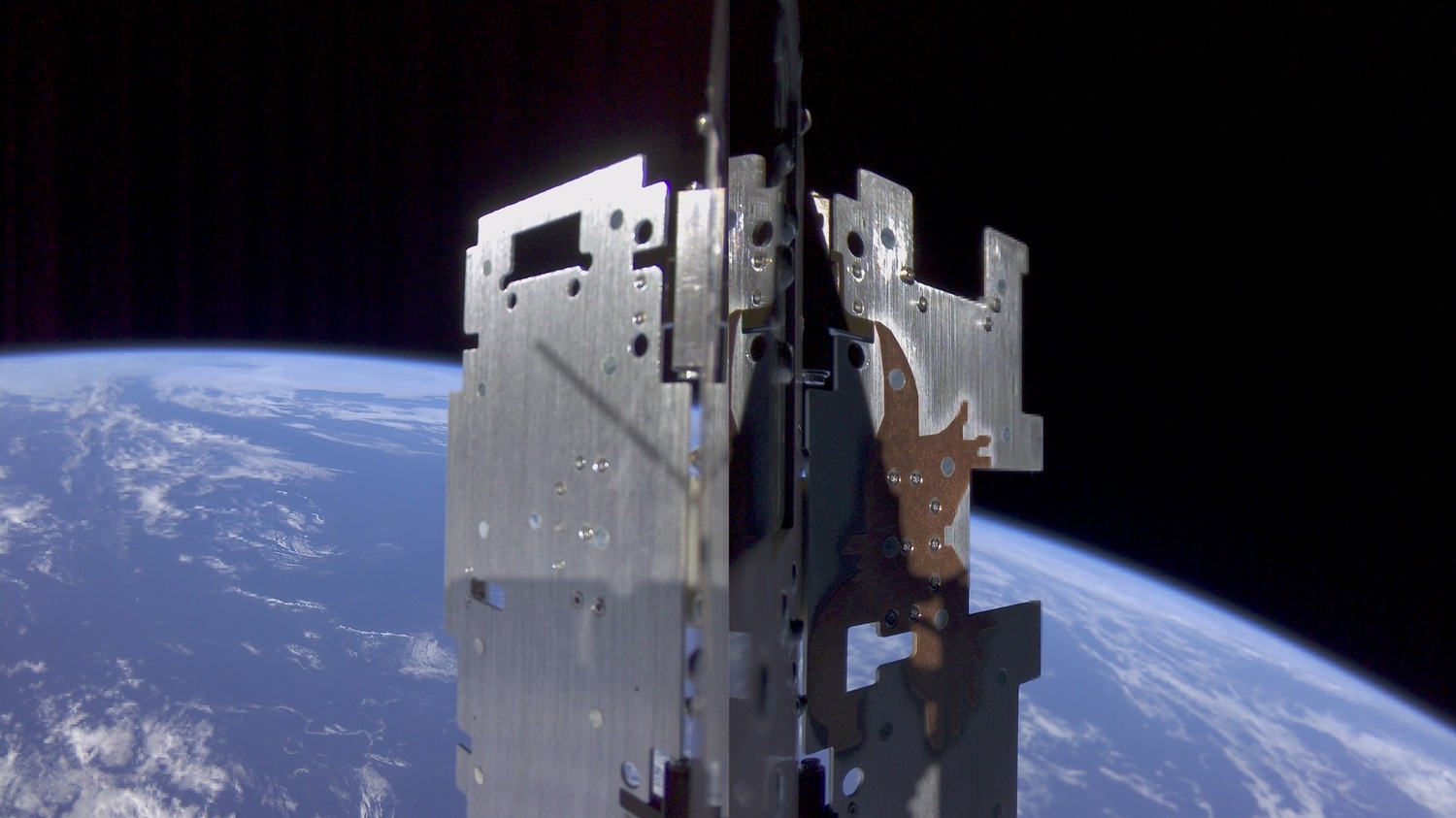 SpIRIT’s radiators after deployment, flying high over the Indian Ocean.   The “Eagle”, a copper structure on the right radiator can be seen, which is designed to help dissipate heat from SpIRIT’s thermal management system. 