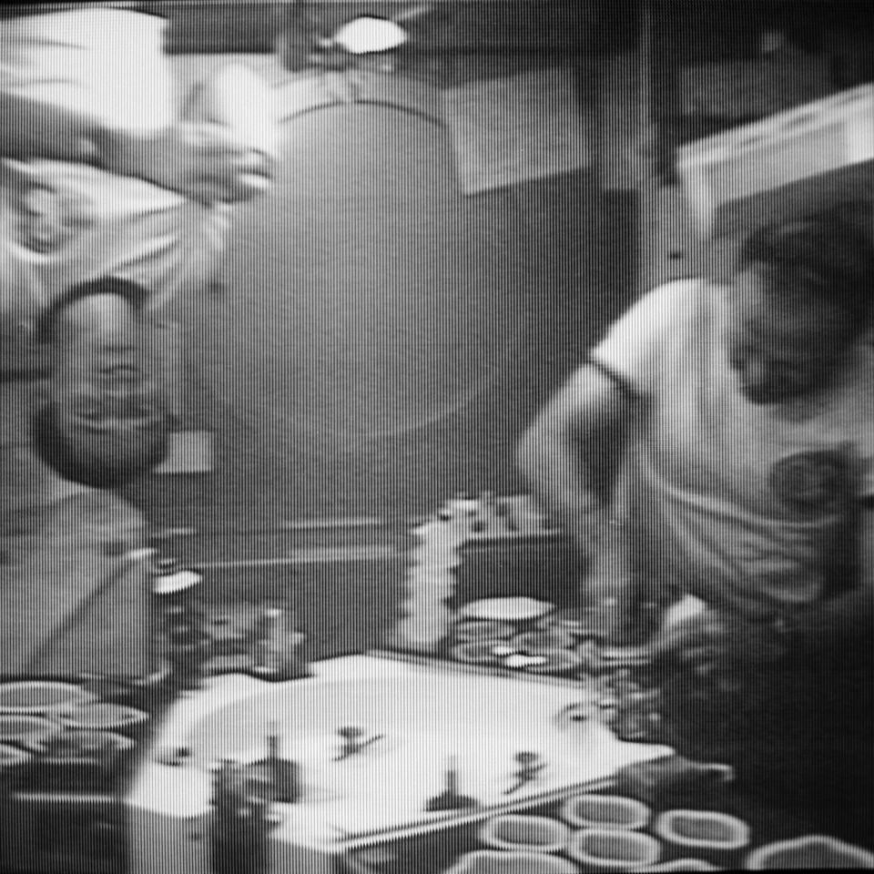 Astronaut Ed Gibson prepares a crew meal on the Skylab space station. In the foreground you can see the dining table and food warming trays.