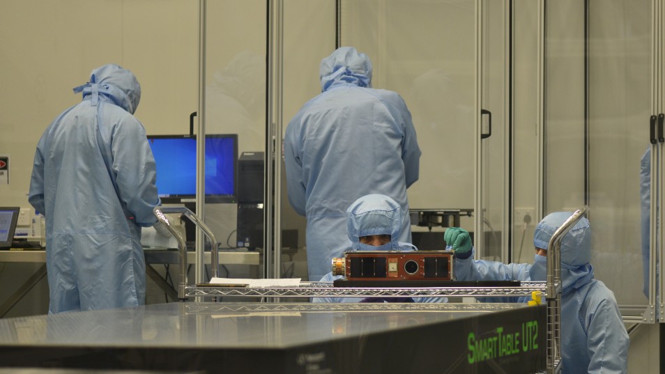 DSTG Engineers Paul Alvino and Harrison Bennett prepare the engineering model spacecraft for measuring the mass properties at the National Space Test Facility in Australian National University