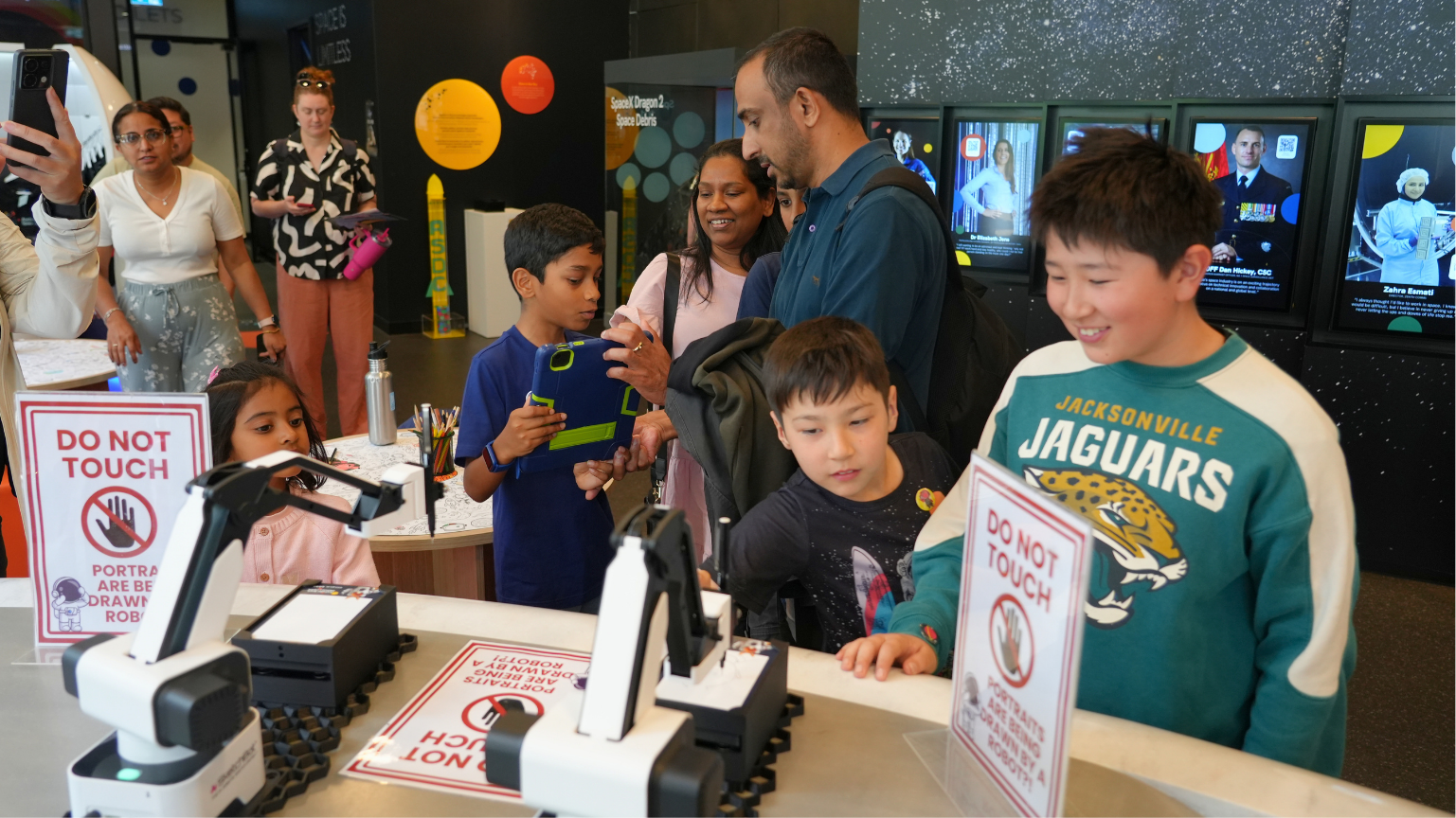 Young space enthusiasts getting their portrait made by a robot. 