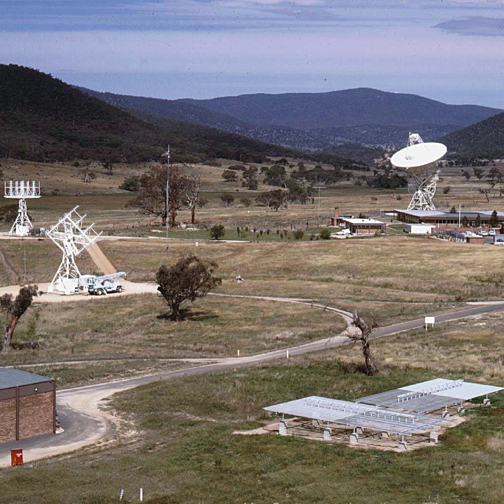 A view across the Orroral Valley STADAN station, with the Minitrack radio interferometry tracking system in the foreground, and the 26-metre antenna in the distance. Credit: www.honeysucklecreek.net 