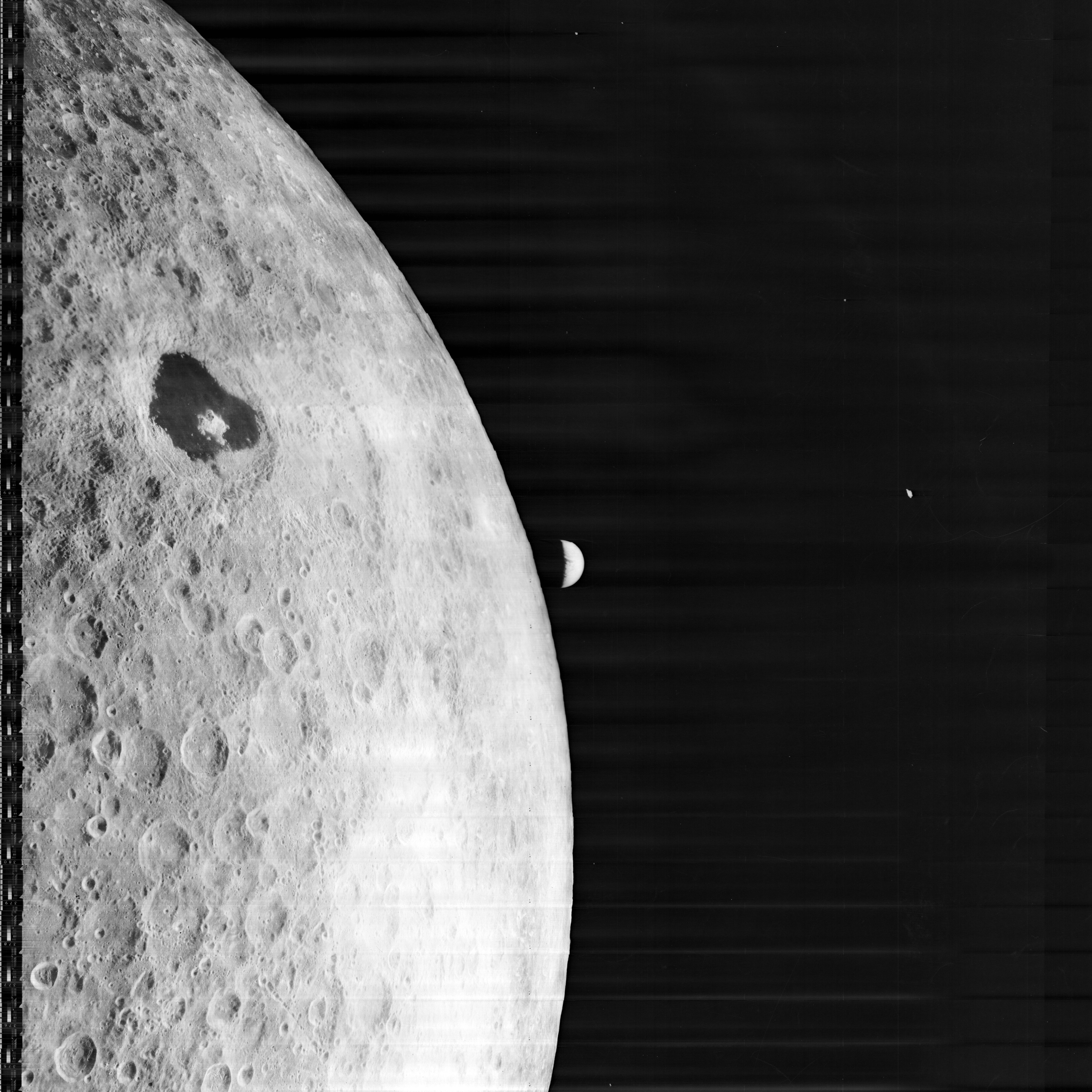 Lunar Orbiter-1 photo of the lunar farside, with the Earth visible in the background, and the dark-floored Tsiolkovsky crater in the upper left.  Credit: NASA