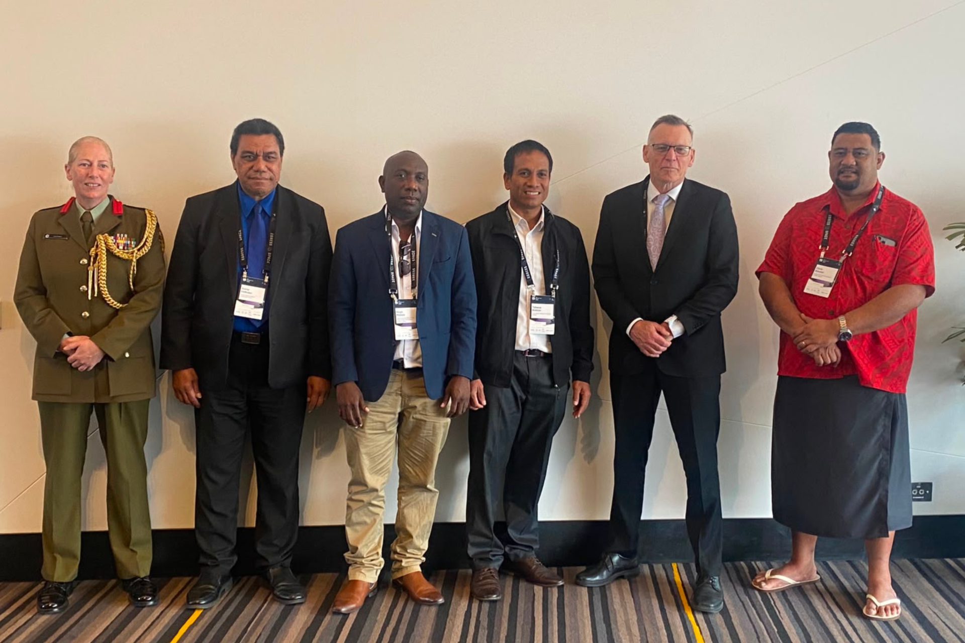 Members of the Pacific Island Countries delegation standing with the New Zealand High Commissioner, Andrew Needs, and Colonel Lisa Kelliher.