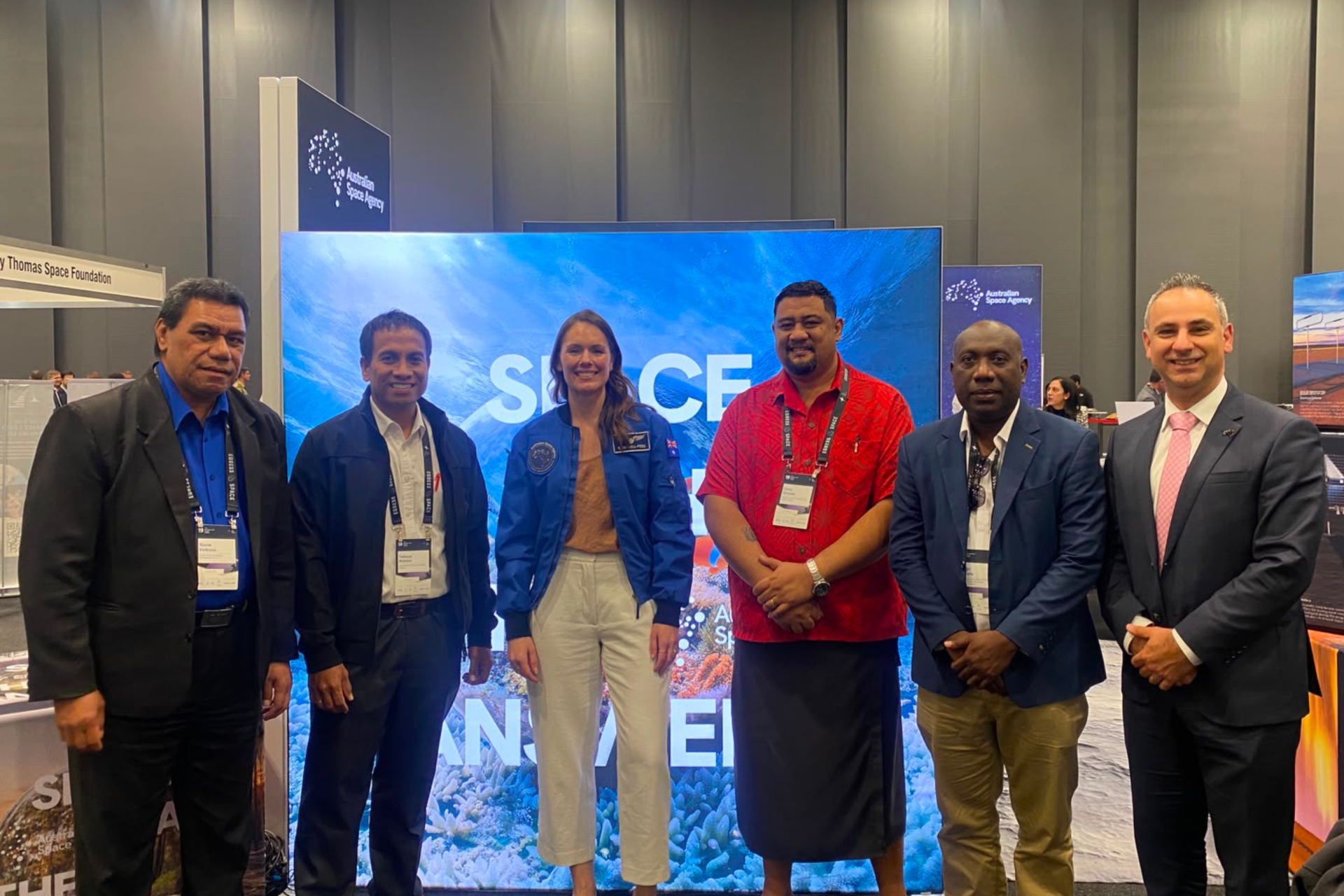 Delegates from (left to right) Tonga, Kiribati, Samoa, and the Solomon Islands stand for a photo with Astronaut, Katherine Bennell-Pegg at the Australian Space Agency Booth. 