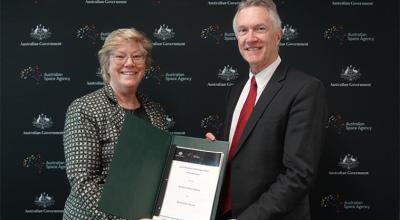 Photo of Australian Space Agency and EM Solutions leaders holding the signed agreement.