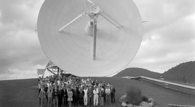 Black and white photo of the Honeysuckle Creek team in front of the telescope.