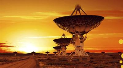 Photo of multiple radio astronomy observatories dishes in outback sunset.