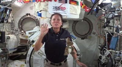 An astronaut aboard a space shuttle, with a toy kangaroo floating in front