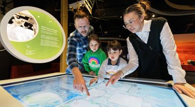 Family watching a space exhibit.