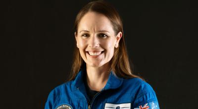woman in an astronaut unifrom smiling.