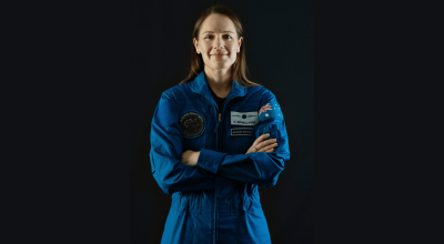 woman in an astronaut unifrom smiling.