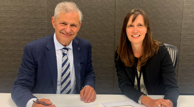 Two people posing after signing an agreement.