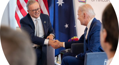 Two people shaking hands over an international agreement.