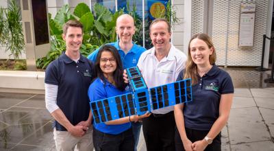 People posing with a spacecraft