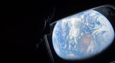 NASA astronaut and Artemis II Commander Reid Wiseman peers out of one of the Orion spacecraft's main cabin windows, looking back at Earth, as the crew travels towards the Moon.  Image Credit: NASA