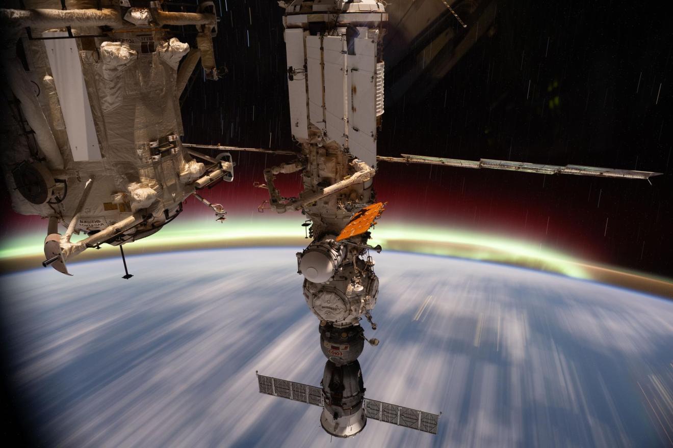 The aurora australis streams above Earth's horizon