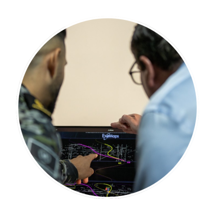 Defence personnel pointing at space data on a screen