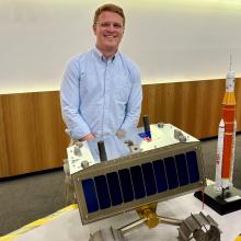 Jack Rintoul with a lunar rover model and rocket display, highlighting Australia's space technology and exploration capabilities.