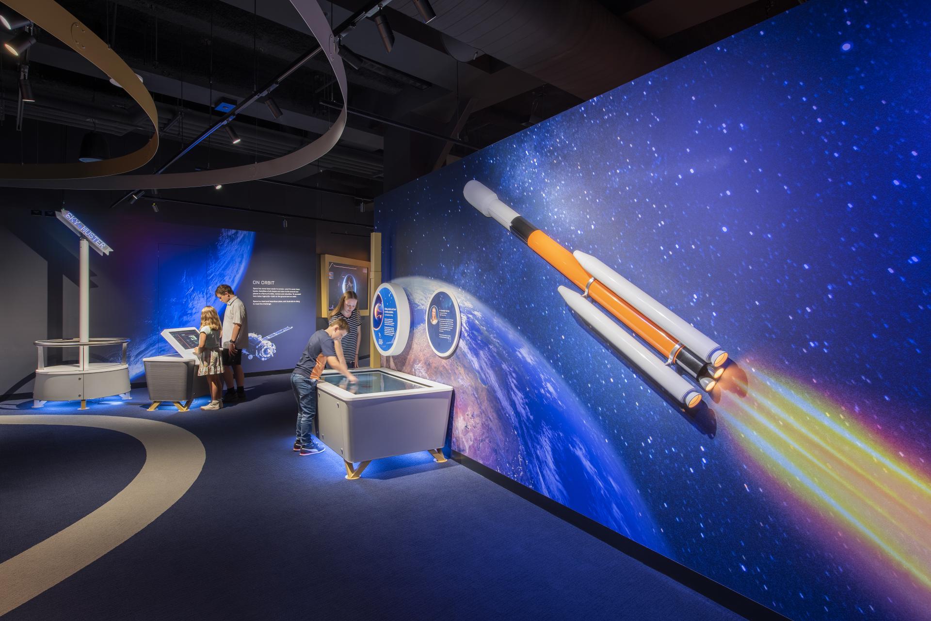 Kids interact with space museum exhibit touch screeens
