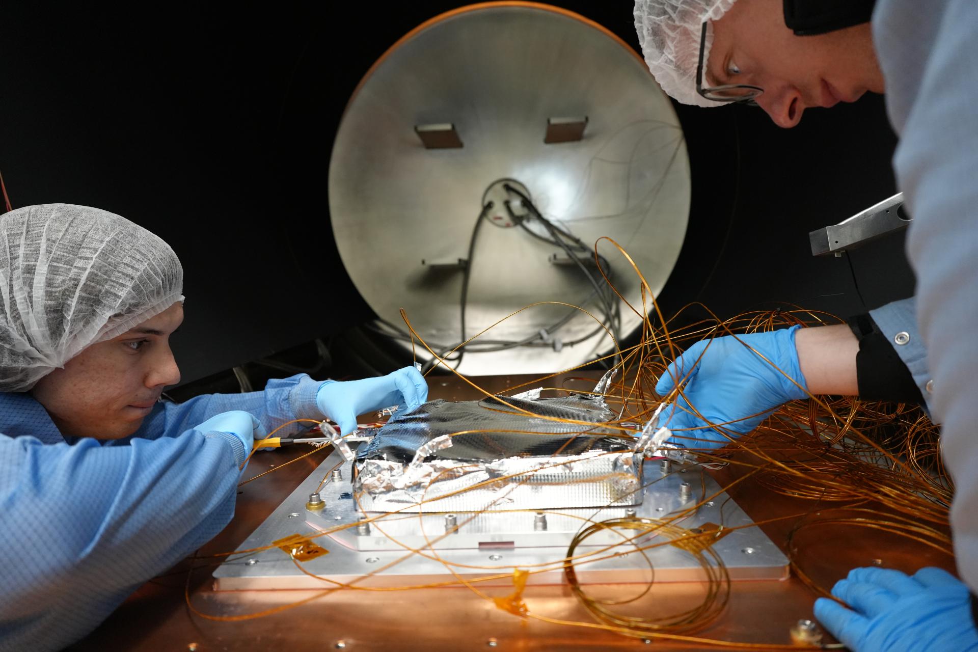 Two technicians working on QuantX’ s optical clock technology.